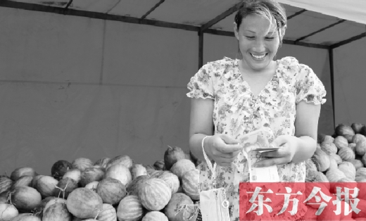 昨日，開封瓜農(nóng)史瑩瑩幸福地?cái)?shù)著賣瓜錢