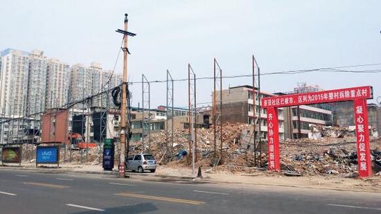015年5月31日，在社區(qū)干部的帶頭拆遷下，親賢社區(qū)的“城中村改造”拉開帷幕。由于前期“清產(chǎn)核資”及補(bǔ)償標(biāo)準(zhǔn)等因素，拆遷改造工作推進(jìn)并不順利。圖為位于體育西路東側(cè)集體所有的商鋪率先被拆遷完畢，用于遮擋的圍擋正在施工中。（拍攝：2015年9月16日）