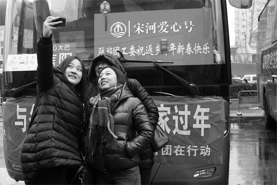 昨天上午8時(shí)，鄭州正道中環(huán)百貨廣場(chǎng)，準(zhǔn)備回家的老鄉(xiāng)在愛(ài)心大巴車前合影留念