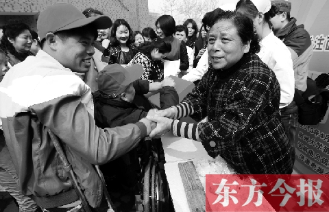 昨日，鄭大四附院的大樓前，“面人鄭”鄭玉芬（右）向前來(lái)捐款的殘疾人表示感謝