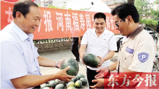 河南福壽園區(qū)域總經理吳正宗（左一）、東方今報發(fā)行中心副總監(jiān)王路喜（中）在街頭給市民送瓜