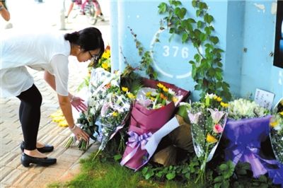 6月8日下午，記者來到廈門公交車爆炸事發(fā)現(xiàn)場橋下，附近已聚集了十幾個自發(fā)前來悼念的市民。橋墩下排放了一圈或黃或白的菊花，還有玖瑰、百合等。
