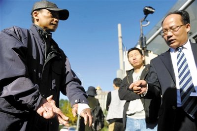 常林鋒在法院外展示雙手，他稱被燙傷的手因刑訊逼供且未得到及時救治