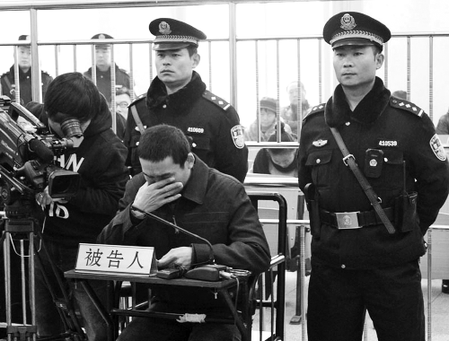 庭審中,29歲的李軍低著頭。