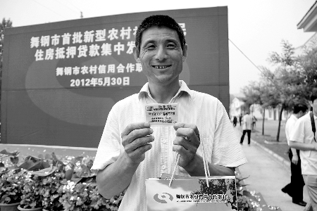 領(lǐng)到貸款，農(nóng)民開心地笑了。