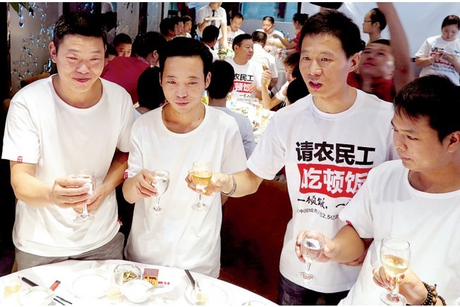 活動發(fā)起人張楠（右二）給農(nóng)民工敬酒。
