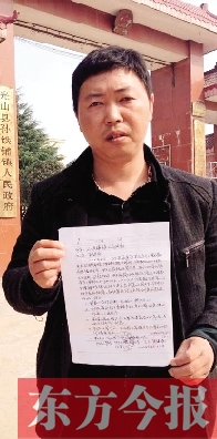 吳大強(qiáng)手持還款協(xié)議在鎮(zhèn)政府門前 吳大強(qiáng)手持還款協(xié)議在鎮(zhèn)政府門前