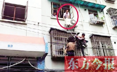 施救現(xiàn)場，劉鵬（圈內(nèi)）先用繩子捆住老太確保安全 勞動報記者 郭娜 供圖