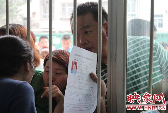 不少家長擠在報名窗口前咨詢報名事宜。