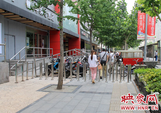 圖中道路左側(cè)的無障礙通道被鋼管隔離,右側(cè)的盲道也被侵占。