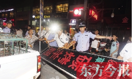 7月8日晚，鄭州市商城路一家占道經(jīng)營(yíng)的攤販招牌被執(zhí)法隊(duì)員“登記保存”