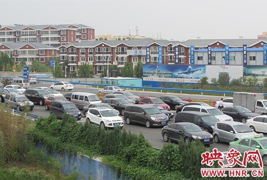 記者看到鄭州機場收費站口車輛排隊，與此形成鮮明對比的是，路的對面（另一半幅）卻車輛較少，通行順暢。