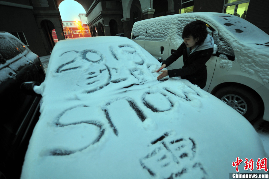 11月18日，行人在車輛的積雪上涂鴉。
