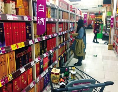 顧客在商場(chǎng)的高檔白酒貨架前駐足挑選。春節(jié)臨近，受“禁令”影響，以高檔白酒為代表的節(jié)日禮品市場(chǎng)面臨考驗(yàn)。記者 王遠(yuǎn)征 攝