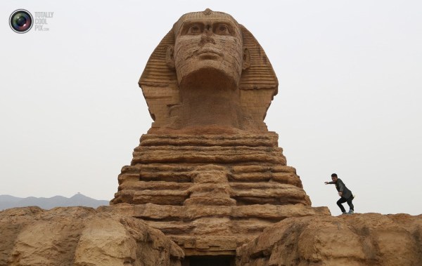 石家莊郊外，一名男子與山寨版獅身人面像合影留念。