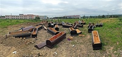 40多副棺木被砸壞后，扔在荒地上。