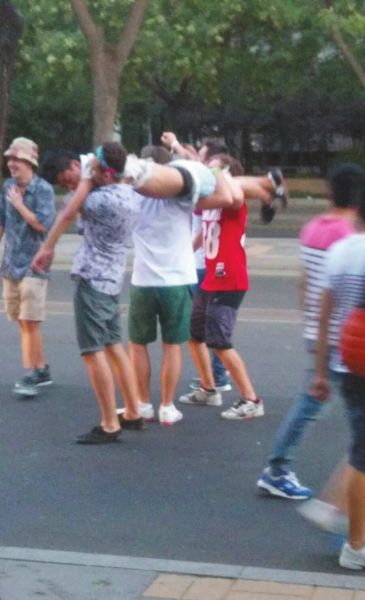 　四名外籍男子一同扛起醉漢拍照。