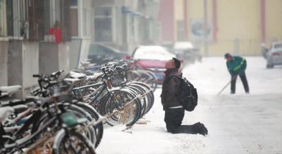 小伙子跪在樓前，一直抬頭看著樓上。 孫立國(guó)/攝