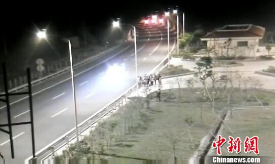 看到車輛經(jīng)過，孩子們便急忙跑到一旁的花圃上?！【焦﹫D　攝