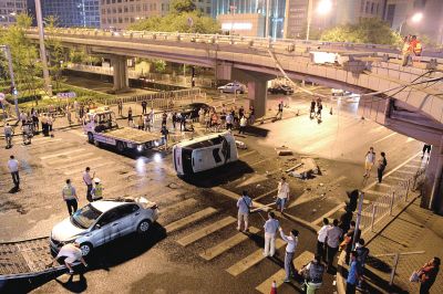 路虎沖下國(guó)貿(mào)橋砸中一輛起亞轎車，橋上厚達(dá)幾十厘米的水泥護(hù)欄被撞斷，碎石四處散落，數(shù)十群眾在現(xiàn)場(chǎng)圍觀。