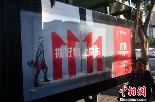 資料圖：11月1日，福州民眾從雙十一廣告牌前經(jīng)過。中新社記者 呂明 攝
