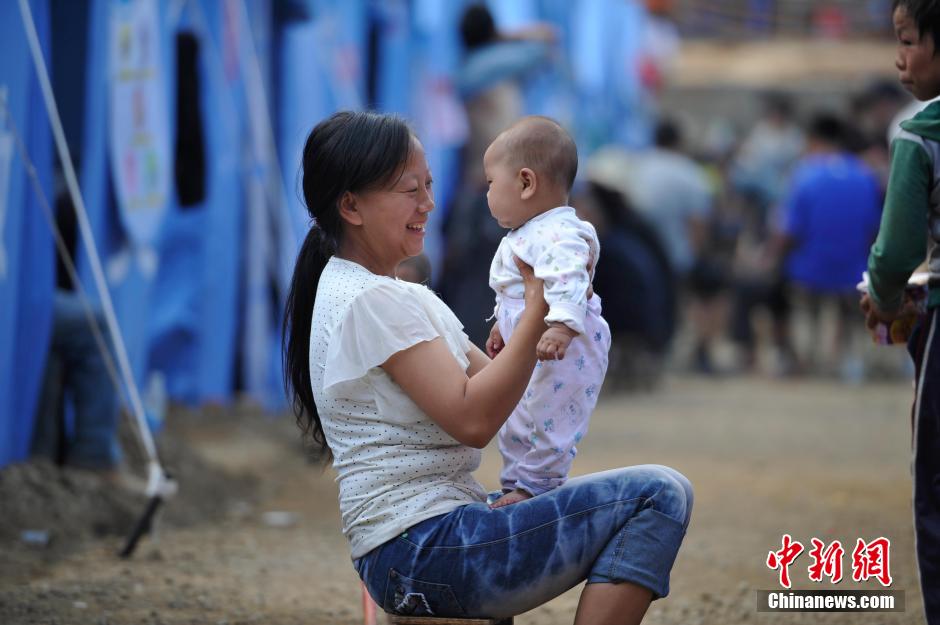 8月6日，一名年輕的母親在和孩子玩樂。