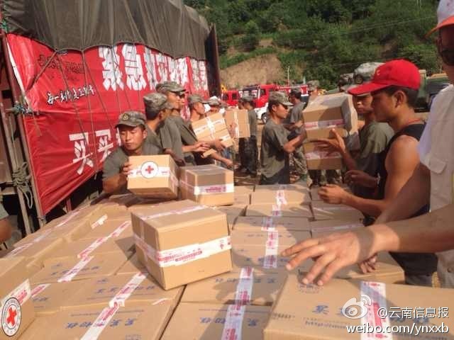 第14集團軍官兵協(xié)助阿迪力將1100余箱切糕從貨車上卸下。