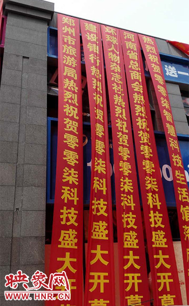 路邊一棟樓上懸掛著二三十條紅色條幅，全部是祝賀一家公司開業(yè)的。