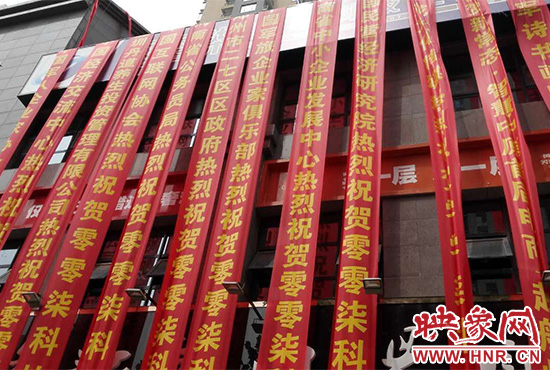 路邊一棟樓上懸掛著二三十條紅色條幅，全部是祝賀一家公司開業(yè)的。