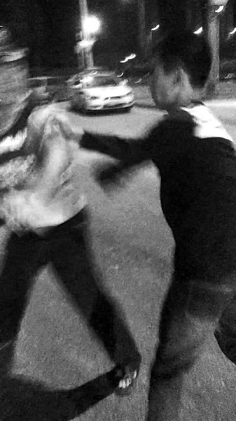 一名男子扯著民警的反光背心一路追打。