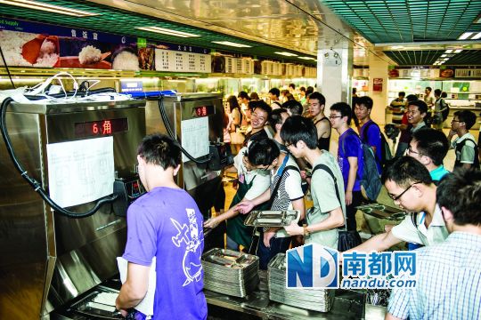 昨日，華南理工大學(xué)一食堂內(nèi)，學(xué)生們正在使用新安裝的自動打飯機(jī)打飯。中新社發(fā)