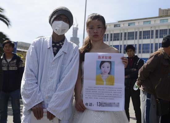 昆明火車站廣場(chǎng)上，24歲的黃習(xí)菊身穿潔白的婚紗，帶著身患白血病的弟弟征婚。