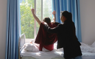 出院前，窗外透進(jìn)一道陽光，打在他的身上。