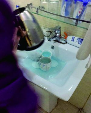 酒店服務(wù)員用潔廁液刷燒水壺和茶杯。