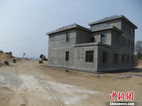 鴨河水庫庫區(qū)邊的新建別墅，一面墻上寫著“拆”，另一邊在加緊施工。吳揚(yáng)　攝