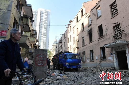 一位花甲老人站在即將拆除的樓房旁，默默地與“蘇聯(lián)樓”告別。　翟羽佳　攝