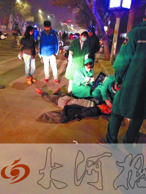 醉漢躺在地上，醫(yī)護(hù)人員對其進(jìn)行檢查。